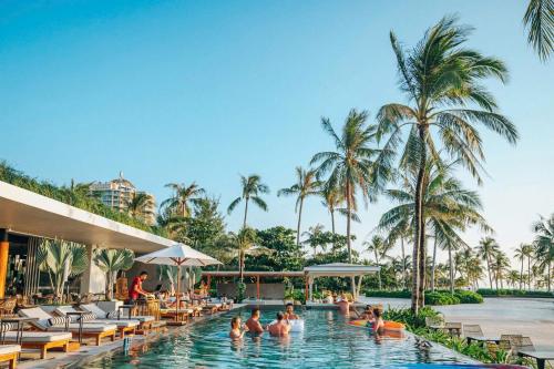 a pool at the resort with people in it at LALU Hotel in Phú Quốc