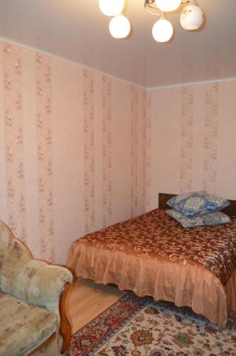 スモレンスクにあるApartamenty na Yubileynoyのベッドルーム1室(ベッド1台、椅子付)
