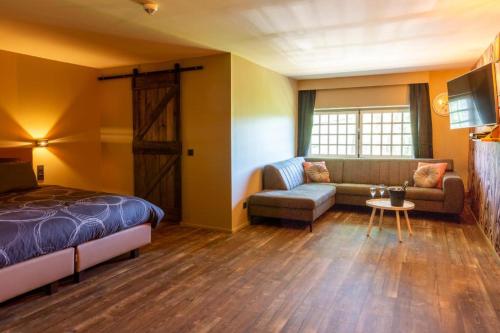 a bedroom with a bed and a couch and a table at lignely in Durbuy
