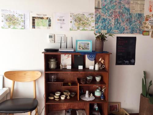 a book shelf with cups and other items on it at Dorandoran Guesthouse in Gyeongju