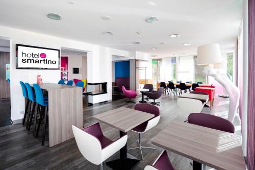 a lobby with tables and chairs and a restaurant at Hotel Smartino in Schwäbisch Hall