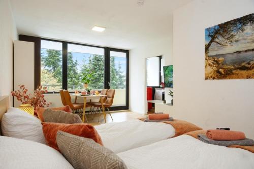 a room with four beds and a dining room with a table at RELAX - ORANGE mit Pool und Sauna in Sonthofen