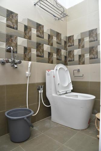 a bathroom with a toilet and a bucket at La Maison Mira in Pondicherry