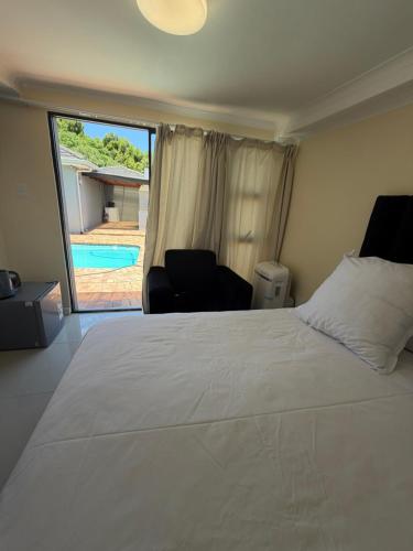 a bedroom with a large white bed and a pool at Joys House in Cape Town