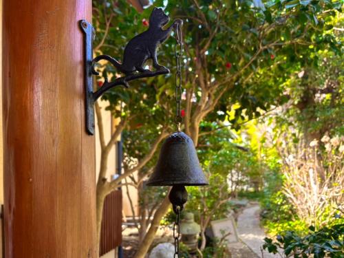 a bell hanging on the side of a house at 風まち in Yawatano