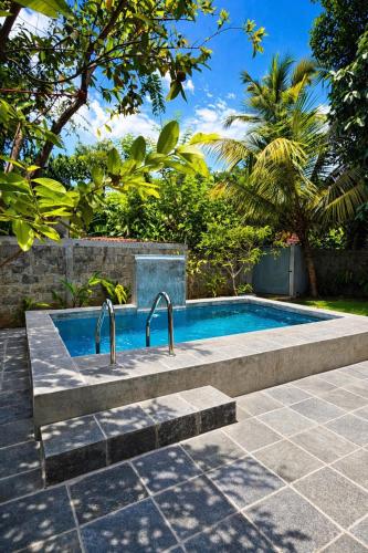 a swimming pool with two faucets in a yard at Samadhi Lagoon Villa in Ratgama Hegoda