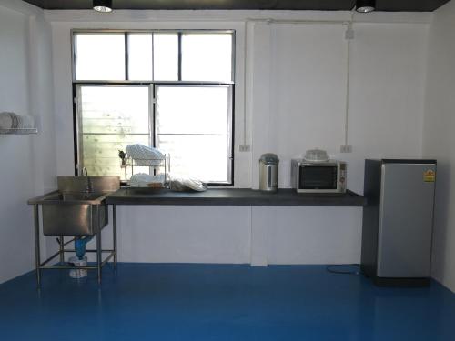 Una cocina con encimera con fregadero y ventana. en Bayview Resort, en Ban Chak Phai