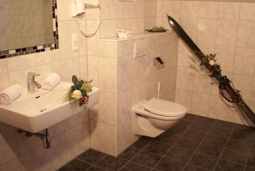 a bathroom with a white toilet and a sink at Hotel Garni Rauch in Sankt Anton am Arlberg