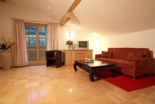 a living room with a couch and a coffee table at Hotel Garni Rauch in Sankt Anton am Arlberg