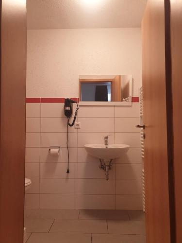 a bathroom with a sink and a phone on the wall at Voigt's Hofpension GbR in Zahna-Elster