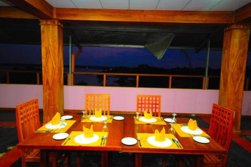 a wooden table with four chairs around it with a tableablish at Hotel Sobana Lake front in Udawalawe