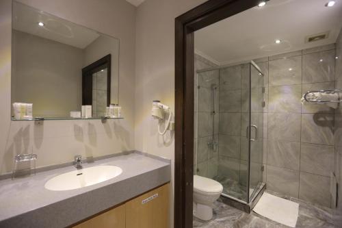 a bathroom with a shower and a sink and a toilet at Jabal Amman Hotel (Heritage House) in Amman