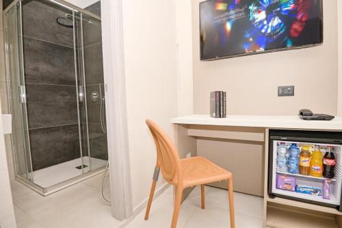 a room with a shower and a table and a chair at Hotel Corallo New in Muravera