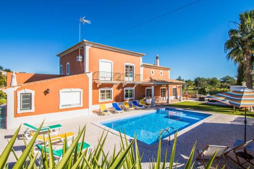 a house with a swimming pool in front of it at Quinta das Yuccas by Algarve Holidays in Boliqueime