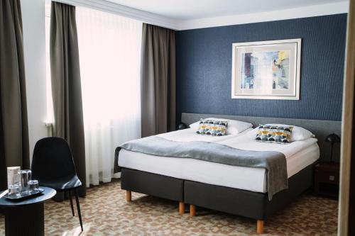 a bedroom with a bed with a blue wall at Hotel Tarnovia in Tarnów