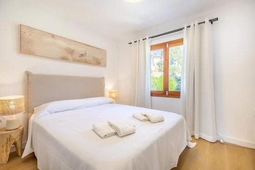 a bedroom with a white bed with two towels on it at Apartment Vida Sana by Sealand Villas in Alcudia