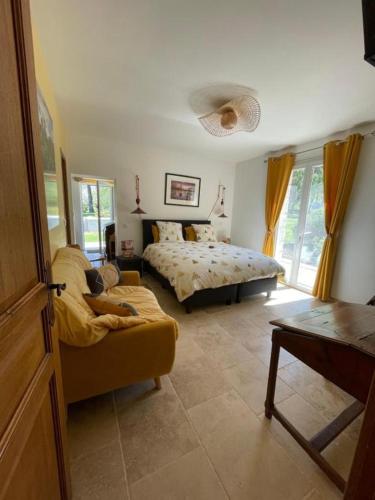 a bedroom with a bed and a couch in a room at L isaro in Anthé