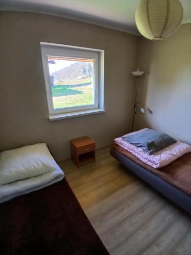 a bedroom with two beds and a window at Tęczowe Wzgórze Bieszczady 887 - 507 - 298 in Wołkowyja