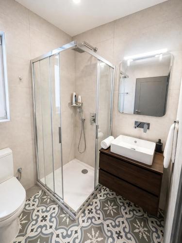 a bathroom with a shower and a sink and a toilet at Iris -Paola Modern Townhouse in Paola