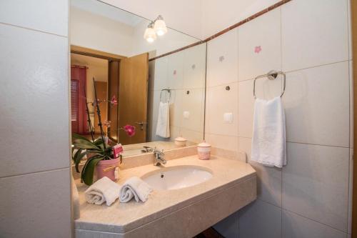 a bathroom with a sink and a mirror at Quinta das Yuccas by Algarve Holidays in Boliqueime
