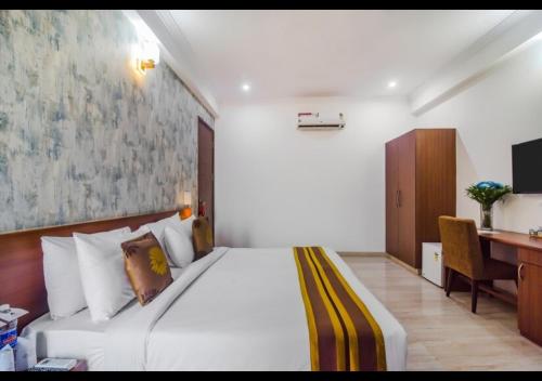 a bedroom with a large bed with a desk and a computer at Royal Residence Golf Course Road in Gurgaon