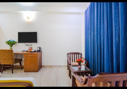 a room with a desk and a blue curtain at Royal Residence Golf Course Road in Gurgaon