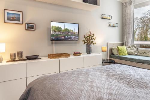 a bedroom with a bed and a tv on a wall at Mühlenstraße 19 Ferienwohnung 50227 in Carolinensiel