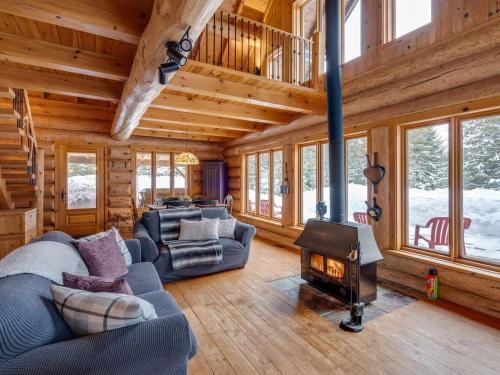 a living room with a fireplace in a log cabin at Spa & River - Hidden chalet - Chalet cache in Saint-Alexis-des-Monts
