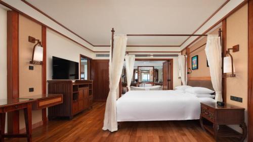a bedroom with a large white bed and a desk at Horizon Resort & Spa Yalong Bay-Yalong Bay Central in Sanya