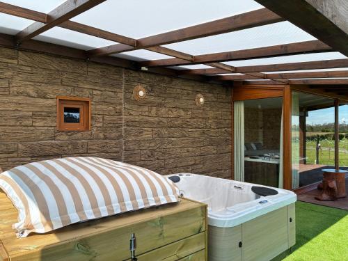a hot tub in a backyard with a roof at O REFUXIO DOS CEBREIROS in Mazaricos