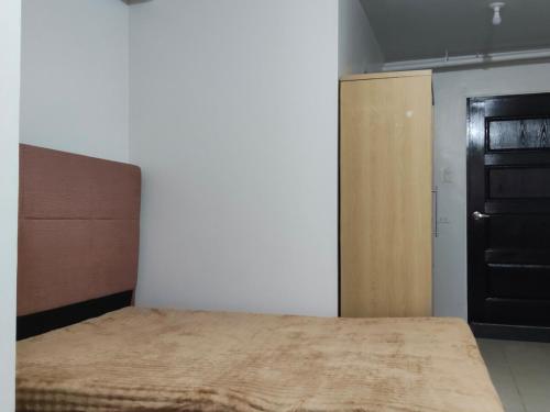 a bedroom with a bed and a wooden cabinet at Zefe's Hideout in Lapu Lapu City