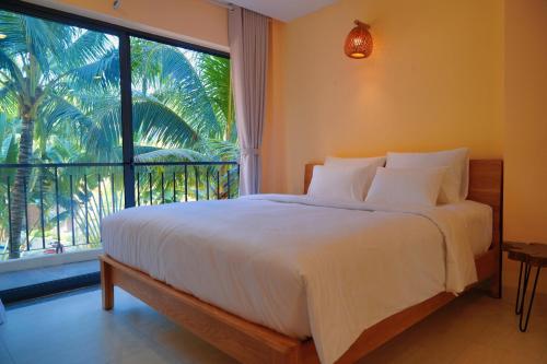 a bedroom with a bed and a large window at Cham Riverside in Thôn Xuân Lạc