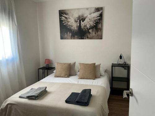 ein Schlafzimmer mit einem Bett, auf dem zwei Handtücher liegen in der Unterkunft Monasteriohome Apto2 in Ibdes