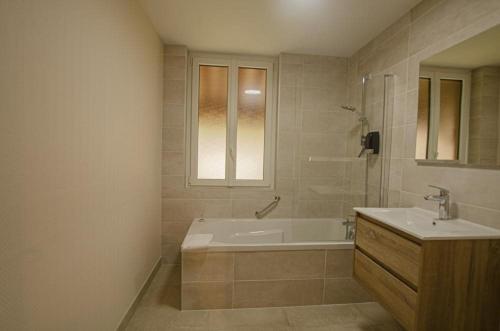 a bathroom with a bath tub and a sink at Gîtes du Château de Crespy in Crespy-le-Neuf