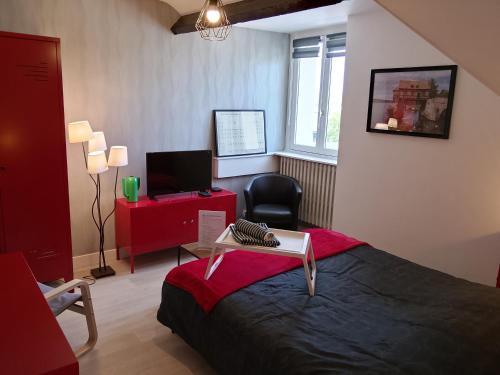 a bedroom with a bed with a desk and a chair at L'escale Vernonnaise in Vernon