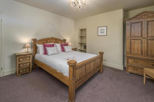 a bedroom with a large wooden bed and a dresser at 2 Bed in Warkworth oc-coq95 in Warkworth