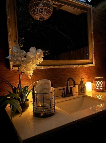 a bathroom sink with a mirror and a towel at Pipeline Tropical Bungalow in Haleiwa