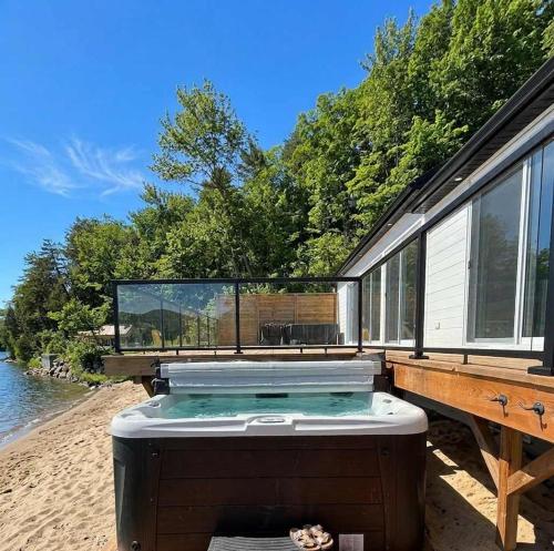 a house with a hot tub on the beach at View Spa and St-Lawrence River - The DG Chalet in Sainte-Petronille