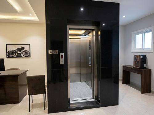 a glass shower in a room with a table and a desk at Hotel HiCity Comfort Near DLF Cyber City & AIG Hospital in Hyderabad