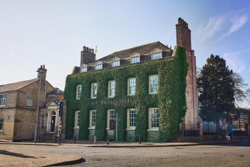 a green building with ivy on it on a street at The Old Bridge in Huntingdon