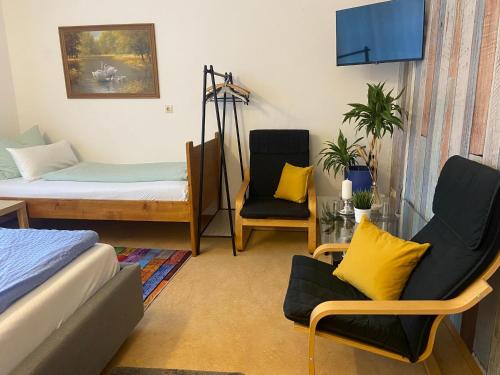 a room with a bed and two chairs in it at Hermann Ferienwohnung in Wechingen