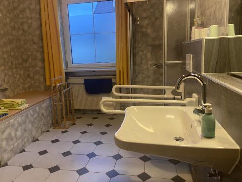 a bathroom with a sink and a window at Hermann Ferienwohnung in Wechingen