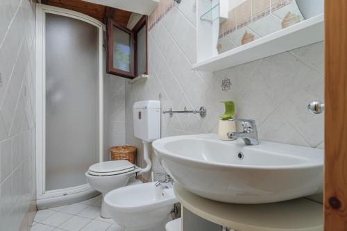 a white bathroom with a sink and a toilet at Casa Gianpiero San Teodoro in San Teodoro