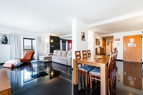 a kitchen and living room with a table and a couch at Rocha Tower 13D - Skyline Ocean View in Portimão