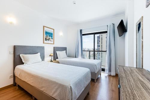 a hotel room with two beds and a window at Rocha Tower 13D - Skyline Ocean View in Portimão