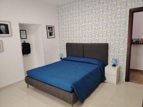 a bedroom with a bed with a blue blanket at Tulla's in Giardini Naxos