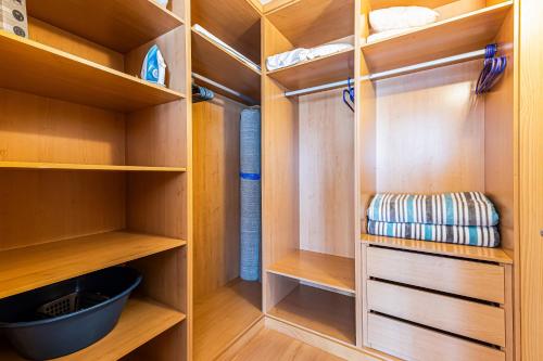 a walk in closet with wooden shelves at Rocha Tower 13D - Skyline Ocean View in Portimão