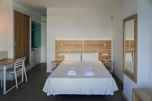 a bedroom with a bed and a desk and a table at ENDLSS BEACH & DISCO HOTEL IBIZA Adults Only in San Antonio Bay