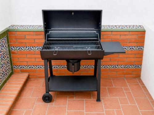a barbecue grill sitting in front of a brick wall at Casa Rural con piscina privada y jardines - LA CASILLA in Cájar