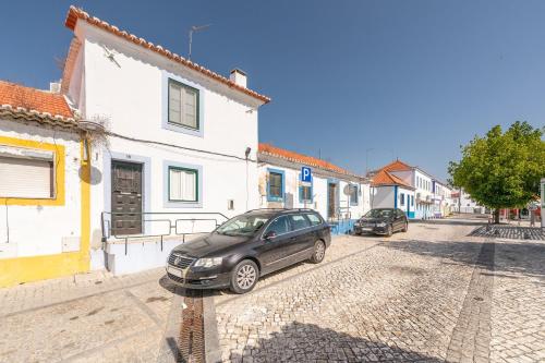 a car parked on a cobblestone street in a town at GuestReady - Enchanting retreat in Alcácer do Sal in Alcácer do Sal